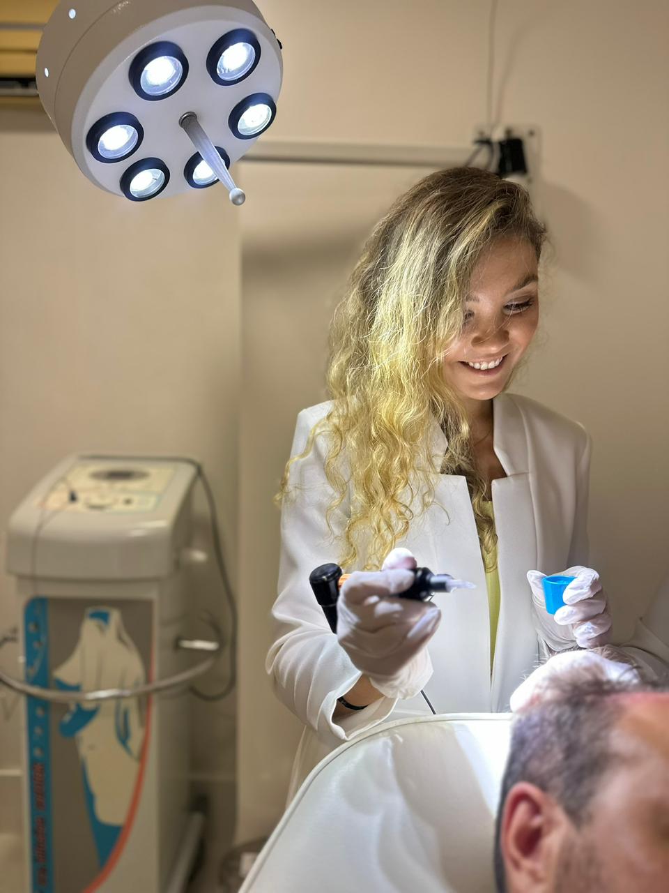 Dra. Gabriela realizando procedimento dermatológico capilar